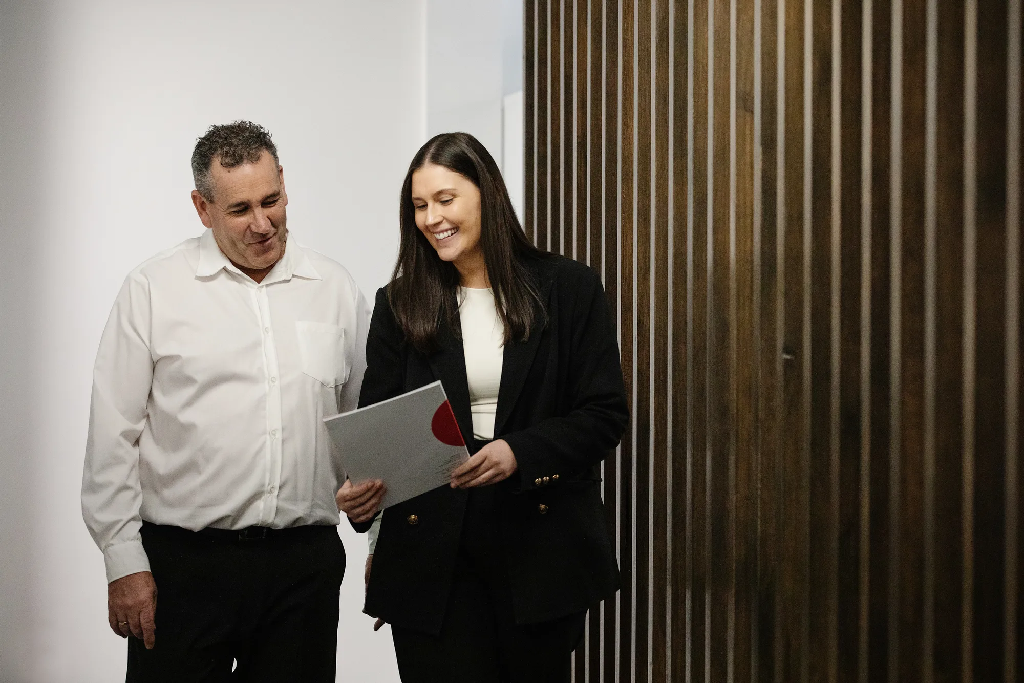 A client and a conveyancer reading a Beck Legal folder together.