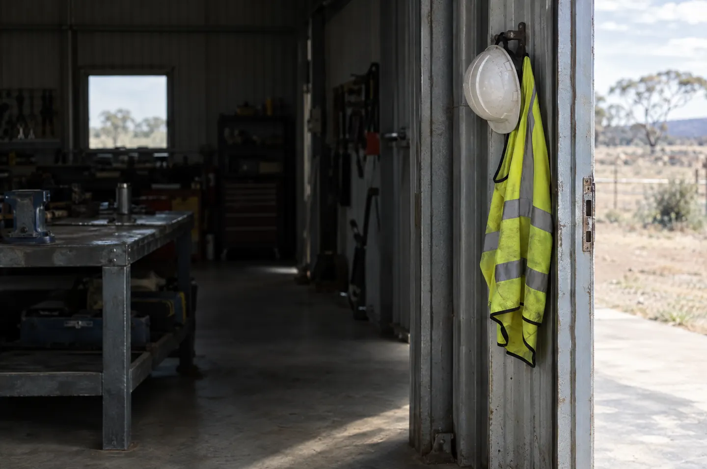 A high-vis vest and hard hat on a workshop hook. Placeholder.